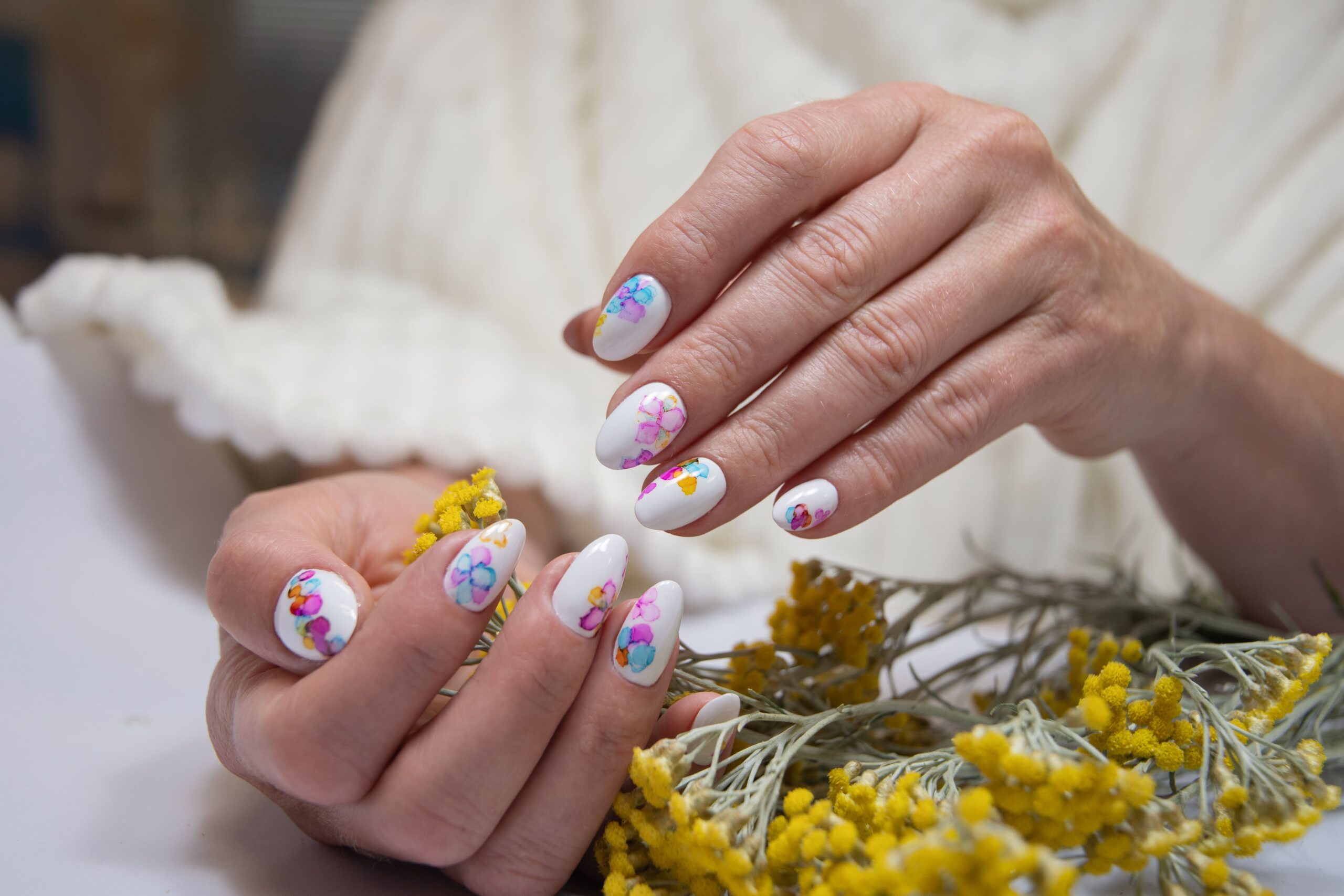 hands-with-beautiful-multi-colored-manicure-hold-bouquet-yellow-flowers-min-scaled.jpg